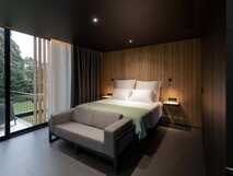 Landscape Furnas Boutique Hotel – Stilvolles Zimmer mit Holzdesign und grünem Ausblick auf São Miguel, ideal für erholsame Aufenthalte.