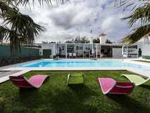 Quinta de Santa Barbara auf Sao Miguel, modernes Hotel mit einladendem Pool und farbenfrohen Liegen in grüner Gartenanlage – perfekt zum Entspannen.