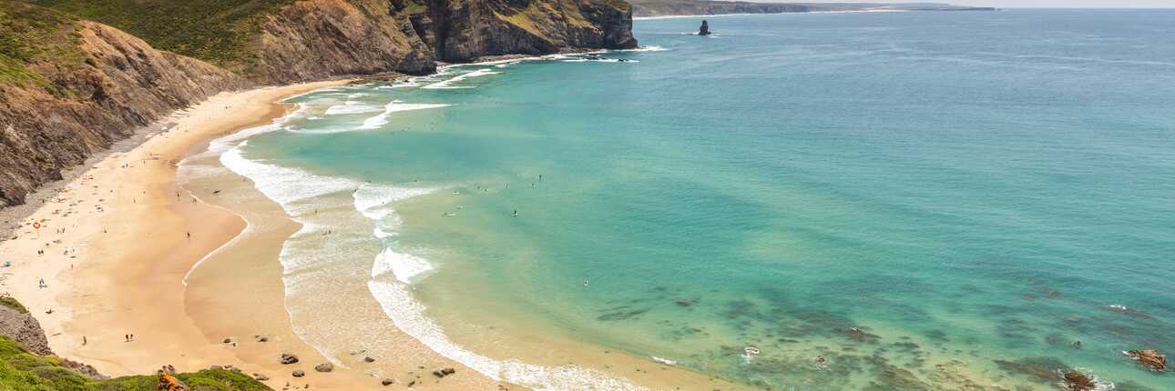 Weißer Strand und blaues Wasser bei einem Urlaub in Portugal am Meer