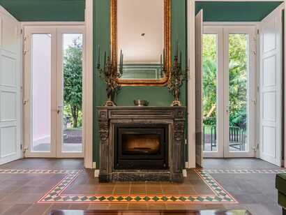 Solar do Cantos Botanic House auf Sao Miguel, stilvoll eingerichtetes Zimmer mit Kamin und Blick in den grünen Garten – ideal für entspannte Wohlfühlmomente.