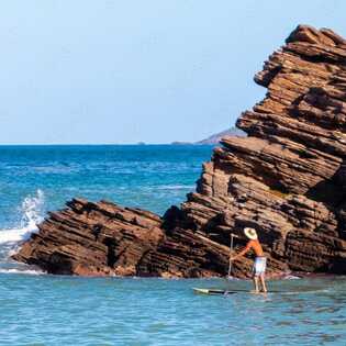 Entdecken Sie die Felsküste des São Rafael Beach bei einer entspannten SUP-Tour.