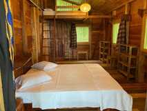 Haus mit einfachem Wohnbereich und vier Betten in Mucumbli Ecolodge Sao Tome