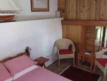 O Palheiro auf Flores – Gemütliches, rustikales Schlafzimmer mit warmem Holzambiente und einladender Atmosphäre für erholsame Nächte.