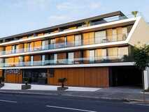 Modernes Hotelgebäude mit Holzfassade und Balkonen – The Shipyard Angra vereint urbanes Design mit Inselcharme auf Terceira.
