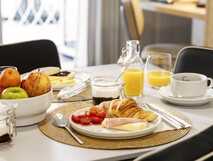 Casa da Galeria auf Sao Miguel, liebevoll angerichtetes Frühstück mit frischem Obst, Croissant, Aufschnitt und Orangensaft für einen perfekten Start in den Urlaub.