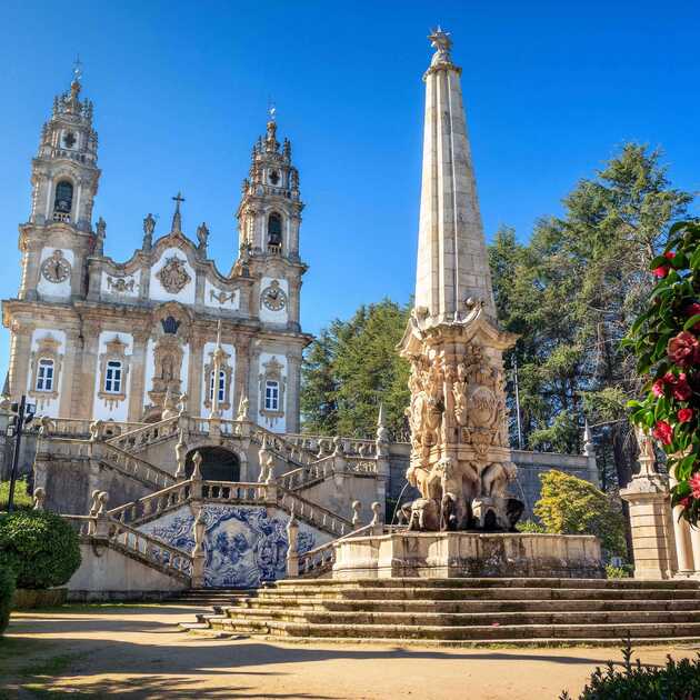 Historische Wallfahrtskirche in Lamego mit großer Statue und Blumen vor der Kirche