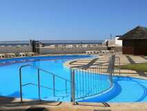 Rundpool mit klarem Wasser, Liegestühlen und Meerblick – perfekter Urlaub mit picotours.
