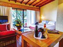 Gemütliches, sonnendurchflutetes Ferienzimmer mit Balkon, frischen Getränken und farbenfroher Dekoration – Wohlfühlurlaub mit picotours.