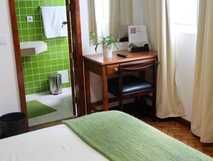 Residencial Alcides auf Sao Miguel, gemütliches und helles Zimmer mit grünem Bad, ideal für erholsame Aufenthalte bei picotours.