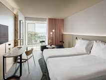 Hotel Azoris Royal Garden auf Sao Miguel, modernes und lichtdurchflutetes Zimmer mit Balkon und Meerblick – perfekter Komfort für entspannte Urlaubstage bei picotours.