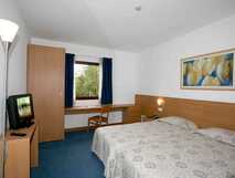 Hotel Matriz auf Sao Miguel – Komfortables Zimmer mit hellen Holzmöbeln, gemütlichem Doppelbett und ruhigem Ambiente für entspannte Urlaubstage.