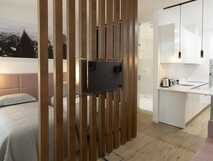 Aparthotel Horta Bay – Modernes, stilvoll gestaltetes Apartment mit offener Küche und gemütlichem Schlafbereich.