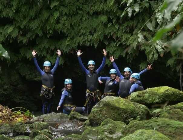 Gruppe von Abenteurern beim Canyoning in einem dichten Wald auf São Miguel