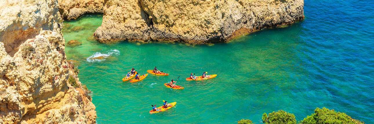viele gelbe Kanus im türkisblauen Wasser, von Felsen umgeben: eine beliebte Sehenswürdigkeiten der Algarve