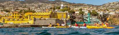 Eine Gruppe ist mit den Kayaks vor den Küsten Madeiras unterwegs.
