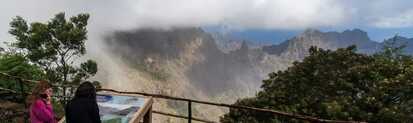 Zwei Frauen betrachten eine Informationstafel mit Aussicht auf die nebelverhangenen Berge von Santo Antão auf Cabo Verde.