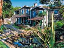 Vulkansteingebäude des Aldeia da Fonte Nature Resort mit Seerosenteich und tropischem Garten auf der Azoreninsel Pico