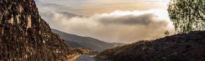Panoramablick auf eine kurvige Bergstraße auf den Kapverden mit dramatischem Himmel und Nebelschwaden – perfektes Klima für Wanderer.