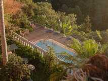 Das rosafarbene Gebäude des Villa Alto Boutique Hotels mit Pool und umgebender Landschaft