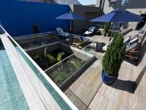 Casa Hintze Ribeiro Aparthotel auf Sao Miguel, moderne Sonnenterrasse mit Pool und gemütlichen Liegestühlen für entspannte Urlaubsmomente.