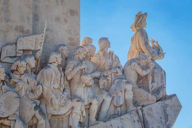 Steinmonument mit historischen Entdeckern, darunter Ferdinand Magellan, am Entdeckerdenkmal in Lissabon, Portugal.