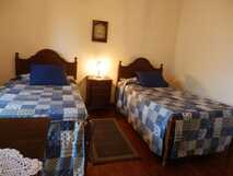 Casas do Frade auf Sao Miguel, gemütliches Doppelzimmer mit rustikalem Charme und blauen Patchwork-Bettdecken, ideal für erholsame Nächte bei picotours.