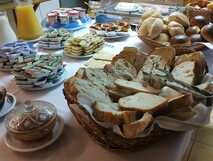 Guesthouse Comodoro auf Flores, reichhaltiges Frühstücksbuffet mit frischem Brot, Aufstrichen und Säften für einen perfekten Start in den Tag.