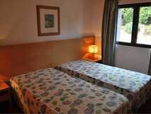 Nossa Senhora da Estrela auf Sao Miguel – Gemütliches Doppelzimmer mit floraler Bettwäsche und natürlichem Licht, ideal für entspannte Urlaubstage.