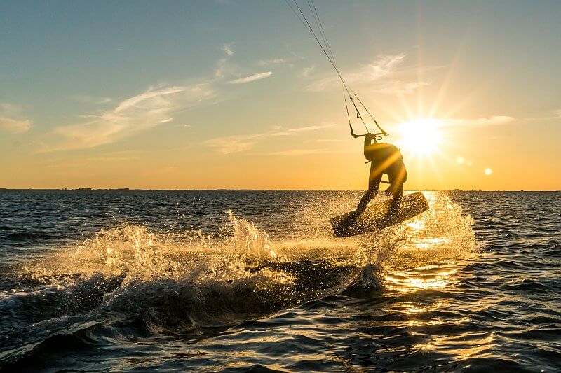 Kitesurfer springt über das Wasser auf den Kapverden – sportliches Highlight in den besten Revierzonen.