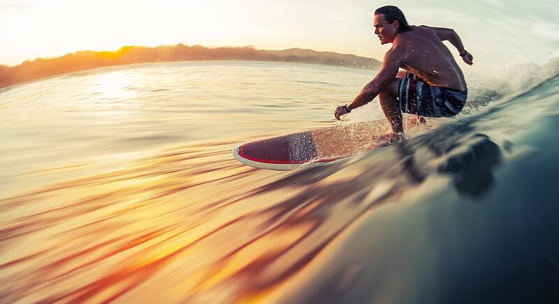 Surfer gleitet bei Sonnenuntergang über eine Welle auf den Kapverden – perfekte Bedingungen für Wellenreiten.
