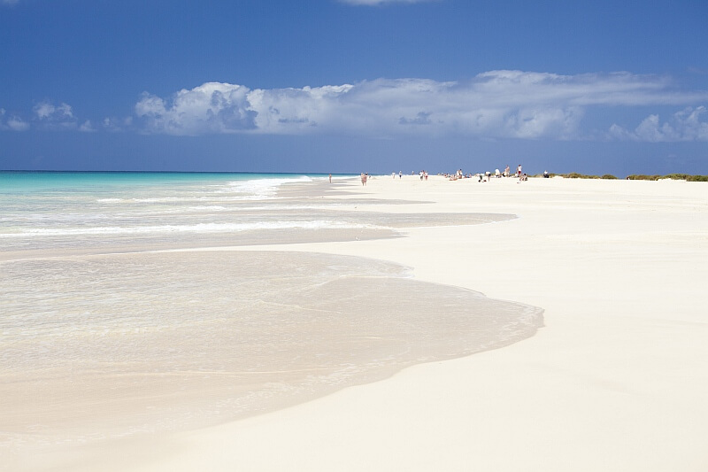 Feiner, weißer Sandstrand von Santa Monica auf Boa Vista, Kapverden, mit türkisblauem Meer unter klarem Himmel.